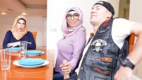 Hijab-wearing female providing a hand job from under the table