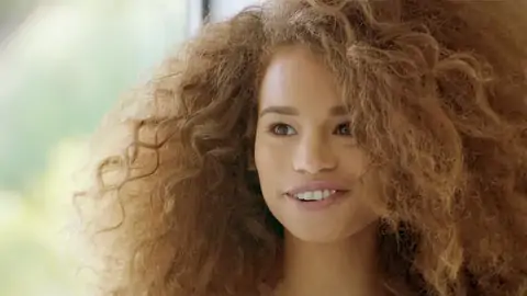 Teenager black with wavy hair is railing a massive pecker on the bed